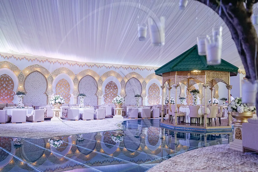 Pavillon de réception aux arcades illuminées, reflet sur l'eau, scénographie d'exception, Rahal Maître Traiteur