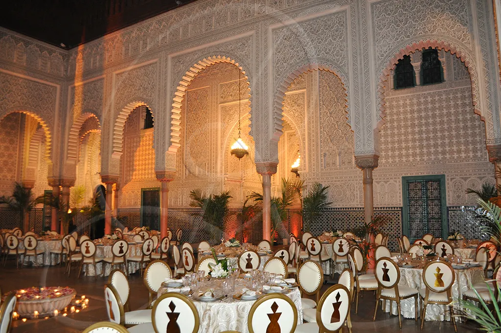 Patio mauresque dressé pour une réception, lumière chaude et profondeur, Rahal Maître Traiteur